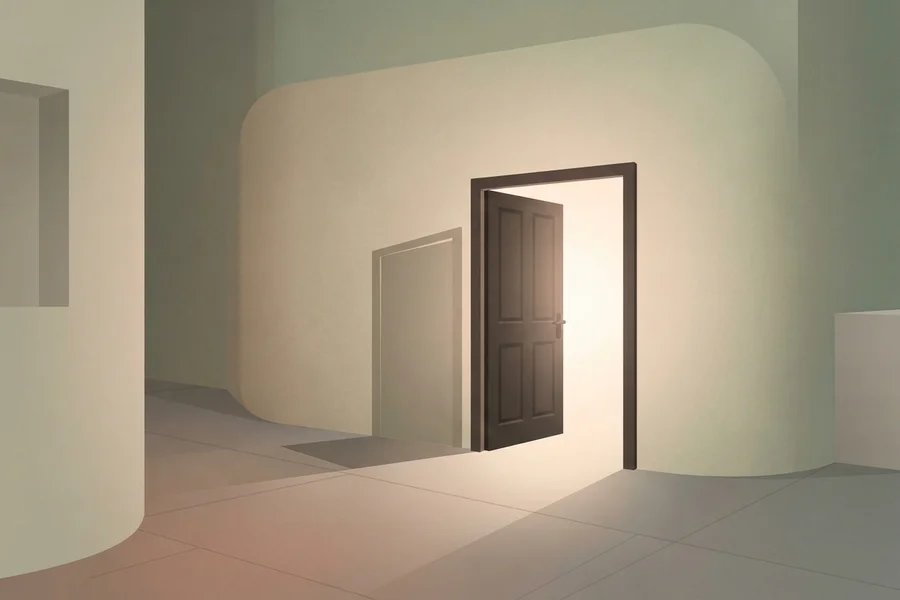 Puerta abierta que deja entrar la luz al final de un pasillo en penumbra.